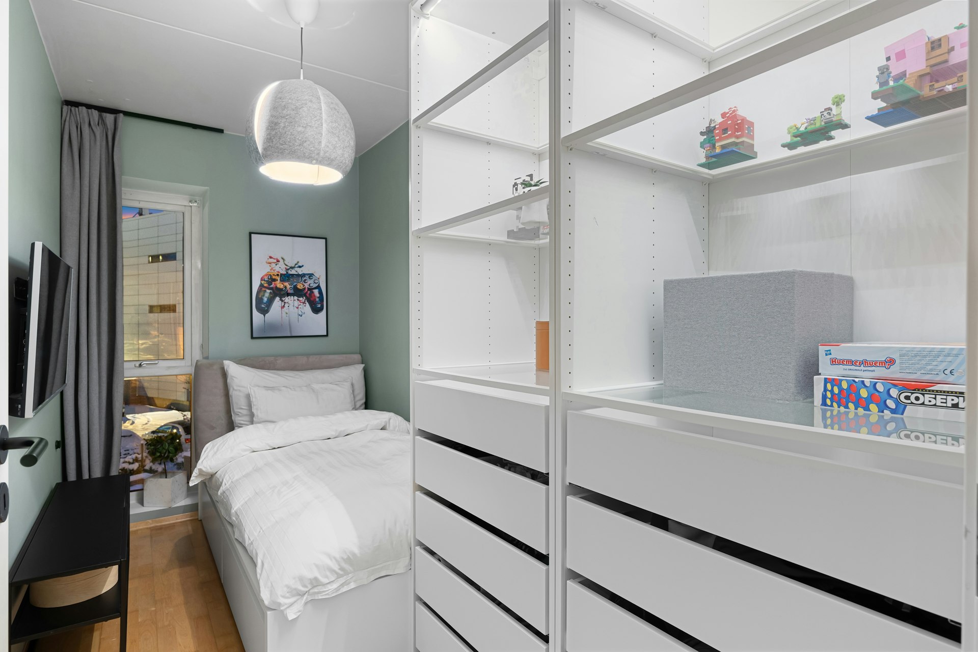 A room with a bed, desk, and shelves
